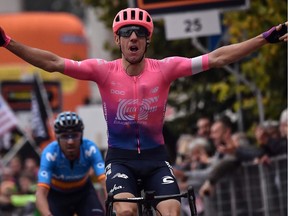 TOPSHOT - Canada's Michael Woods (EF Education First) celebrates as he crosses the finish line to win, ahead of Spain's Alejandro Valverde (Movistar) (Rear) the 100th edition of the one-day classic cycling race Milan - Torino on October 9, 2019 between Magenta, west of Milan and Superga, east of Torino.