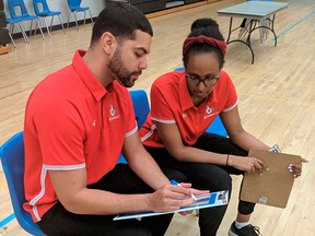 Assistant coach Winta Desta of Ottawa (right) reviews strategy with Bill Crothers Secondary School boys’ senior head coach Yoosrie Salhia.