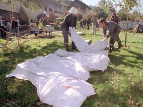 Police carry bodies out of a farm in Cheiry, Switzerland where 23 cultists died in a mass murder-suicide.