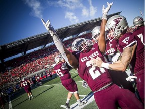 The Gee-Gees celebrate, including #21 Jordan Burgher, toward the end of the 51st Panda Game at TD Place stadium on Saturday.