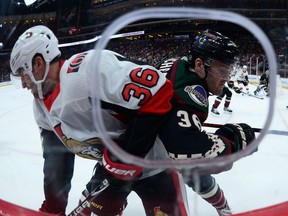 Senators centre Colin White, left, battles Coyotes winger Christian Fischer along the boards during the first period of Saturday's' game in Arizona.
