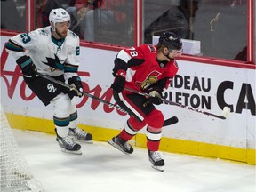 Sharks winger Barclay Goodrow, left, chases Senators forward Filip Chlapik along the boards during the third period of Sunday's game.