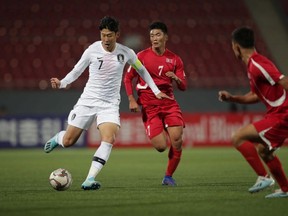 In this photo provided by Korea Football Association, Son Heung-min (white) of South Korea competes for the ball with Han Kwang-Song (red) of North Korea during a World Cup qualifier match at the Kim Il-sung Stadium in Pyongyang, North Korea, on Tuesday, Oct. 15, 2019.