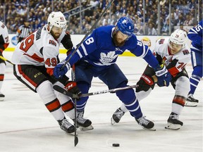 The Senators' Scott Sabourin, left, and Mark Borowiecki battle against the Toronto Maple Leafs' Jake Muzzin during the first period at Scotiabank Arena in Toronto on Wednesday, Oct. 2, 2019.
