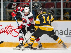 Marco Rossi of the Ottawa 67's and Jordan Frasca of the Kingston Frontenacs trying to take control of the puck.
