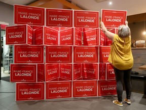 Campaign worker Nathalie Montpetit assembles some Orleans Liberal candidate Marie-France Lalonde signs before the polls close in Ottawa on Monday.