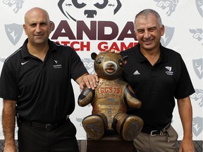 File photo/ Steve Sumarah, Carleton Ravens' men's football head coach, left, and Jamie Barresi, uOttawa men's football head coach, pose by the Panda trophy during a press conference on the GeeGees football field, Thursday August 8, 2013.