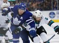 Maple Leafs defenceman Morgan Reilly (44) battles San Jose Sharks counterpart Erik Karlsson at Scotiabank Arena on Friday night. Reilly had what proved to be the winning goal. (Hans Deryk/The Canadian Press)