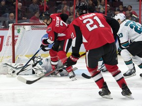 San Jose Sharks goalie Aaron Dell (30) makes a save on Ottawa Senators left wing Brady Tkatchuk on Sunday night at the Canadian Tire Centre. (Marc DesRosiers/USA TODAY Sports)