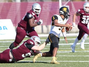 Waterloo quarterback Tre Ford evades Gee-Gees defenders during a playoff game at uOttawa on Saturday, Oct. 26, 2019. Photo: Greg Mason, uOttawa Sports Services