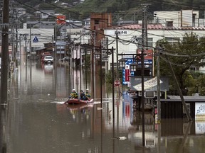 Police officers search an area by boat that was flooded by Typhoon Hagibis on Monday in Marumori, Miyagi, Japan.