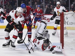 Goaltender Craig Anderson of the Ottawa Senators dives for the puck while teammate Thomas Chabot defends against the Montreal Canadiens during the second period at the Bell Centre on November 20, 2019 in Montreal.