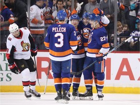 Islanders players celebrate a third-period goal by Noah Dobson against the Senators on Tuesday night.