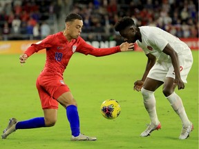 Sergino Dest of the United States attempts to drive past Alphonso Davies of Canada during the CONCACAF Nations League match at Exploria Stadium on November 15, 2019 in Orlando, Florida.