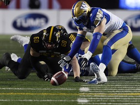 Winnipeg Blue Bombers linebacker Adam Bighill recovers a fumble ahead of Hamilton Tiger-Cats offensive lineman Darius Ciraco during Sunday's game. (USA TODAY SPORTS)