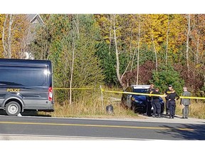 Police vehicles and officers stand outside the Zemel family's home on County Road 5 near Mallorytown on Oct. 11.