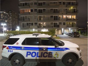 An Ottawa Police Service vehicle sits outside the Sidney Towers apartment building on Sidney Street on Friday evening.