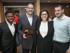 Long-time sports columnist Steve Simmons with wife Sheila, son Michael and CFL legend Michael "Pinball" Cemons at his induction into the Football Writers of Canada Hall of Fame in Calgary, Ab., on Sunday November 24, 2019. Pinball made the introduction speech for Steve. Mike Drew/Postmedia