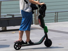 A woman rides an electric scooter.