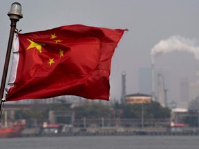 This picture taken on March 22, 2018 shows a Chinese flag fluttering in front of the Shanghai Gaoqiao Company Refinery in Shanghai.