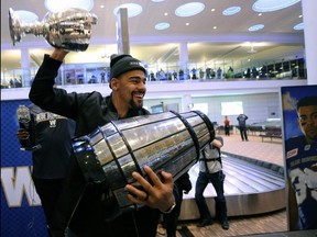 Clutching all sorts of silverware, including part of the Grey Cup, Bombers RB Andrew Harris arrives home in Winnipeg. KEVIN KING/POSTMEDIA