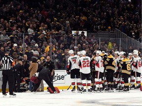 Boston Bruins and Ottawa Senators players watch as Ottawa Senators right wing Scott Sabourin (49) is taken off of the ice on a stretcher after an injury during the first period at the TD Garden.