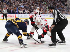 Nov 16, 2019; Buffalo, NY, USA; NHL lineseman Andrew Smith drops the puck for a face off between Ottawa Senators left wing Nick Paul (13) and Buffalo Sabres center Jack Eichel (9) during the first period at KeyBank Center.