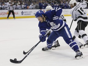 Toronto Maple Leafs forward Mitchell Marner moves the puck against Los Angeles Kings forward Ilya Kovalchuk during the first period at Scotiabank Arena.