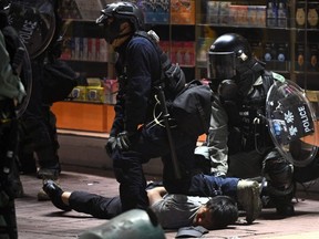 A man is detained as police disperse bystanders in the Mong Kok district of Hong Kong on Sunday, Nov. 10, 2019.