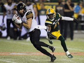 Hamilton Tiger-Cats Luke Tasker (left) gets away from Edmonton Eskimos Monshadrik Hunter during second half CFL action on Friday, June 22, 2018 in Edmonton.