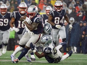 New England Patriots running back Sony Michel runs the ball against Dallas Cowboys defensive back Josh Jones and free safety Xavier Woods (25) at Gillette Stadium in Foxboro, Mass., yesterday. The Patriots defeated the Cowboys 13-9.