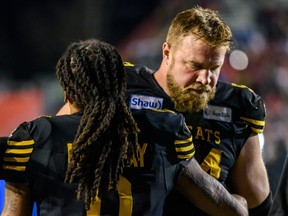 Hamilton Tiger-Cats Chris Van Zeyl gives teammate Rico Murray a condoling hug after their team loses against Winnipeg Blue Bombers during the Grey Cup CFL championship football game on Sunday, November 24, 2019. (AZIN GHAFFARI/Postmedia Network)