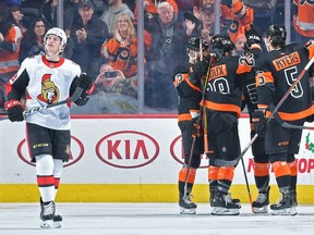 Thomas Chabot of the Senators, left, peers skyward while Flyers celebrate a goal in the first period of Saturday's contest in Philadelphia.