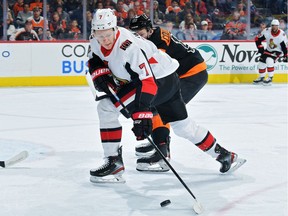 Brady Tkachuk of the Ottawa Senators tries to get a shot off while being defended by Sean Couturier of the Philadelphia Flyers in the first period at Wells Fargo Center on Saturday.