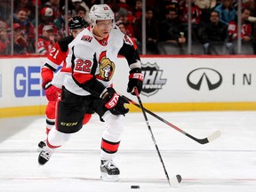 NEWARK, NEW JERSEY - NOVEMBER 13: 
Nikita Zaitsev of the Ottawa Senators takes the puck as Kyle Palmieri of the New Jersey Devils defends at Prudential Center on November 13, 2019 in Newark, New Jersey.