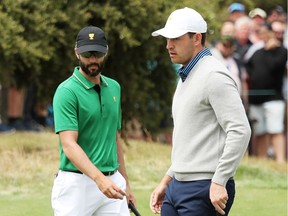 Adam Hadwin of Canada and the International team and Patrick Cantlay of the United States team walk on the first green during Friday foursome matches at the 2019 Presidents Cup at Royal Melbourne Golf Course.
