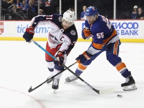 Columbus Blue Jackets' Nick Foligno takes a backhand shot past Johnny Boychuk of the New York Islanders. (GETTY IMAGES)