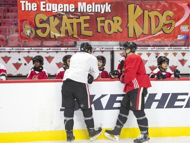 Colin White (L) and Jean-Gabriel Pageau chat with kids as they take part in the 16th annual Eugene Melnyk Skate for Kids at Canadian Tire Centre on Friday, Dec. 20.