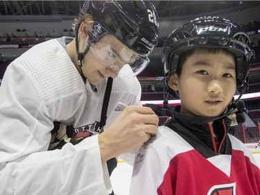 Tyler Tang, 9, gets an autograph from Ottawa Senator Erik Brannstrom during the 16th annual Eugene Melnyk Skate for Kids at Canadian Tire Centre on Friday, Dec. 20.