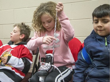 Samantha Northcott, 9, puts laces in her skates as kids get ready in the dressing rooms as Ottawa Senators owner Eugene Melnyk hosted over 100 children at the 16th annual Eugene Melnyk Skate for Kids at Canadian Tire Centre on Friday, Dec. 20.