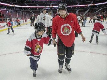 Tyler Ennis skates with a youngster as Ottawa Senators owner Eugene Melnyk hosted over 100 children at the 16th annual Eugene Melnyk Skate for Kids at Canadian Tire Centre on Friday, Dec. 20.