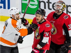 Senators defenceman Mark Borowiecki receives a push in the chest from the Flyers' Andy Andreoff in front of goaltender Marcus Hogberg during tghe first period of Saturday's game at Canadian Tire Centre.
