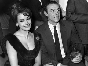 In this file photo taken on Feb. 19, 1965, Sean Connery (R) and Claudine Auger answer journalists' questions at a hotel in Paris.