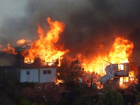 Houses burn following the spread of wildfires in Valparaiso, Chile on Tuesday.
