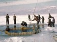 People fish on a frozen Lake Suwa in this handout photo taken around the 1950s, released by Suwa City Museum and obtained by Reuters on November 28, 2019.