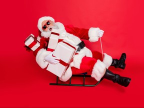 Full length body size view of cheerful cheery funky fat overweight plump gray-haired bearded man sledging carrying purchases isolated over bright vivid shine red background