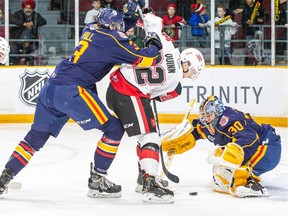 Jack Quinn, middle, of the Ottawa 67's drives between Barrie Colts defenceman Mathew Hill (3) and goaltender Arturs Silovs (30) during an Ontario Hockey League contest against the Barrie Colts at TD Place arena on Saturday, Dec. 14, 2019. The 67's won the game 7-2. Photo by Valerie Wutti/Ottawa 67's.