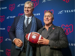 Canadian Football League commissioner Randy Ambrosie, left, poses for photos with Gary Stern, new owner, with partner Sid Spiegel, of the Montreal Alouettes in Montreal on Monday.