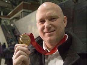 Following a long flight Team Canada assistant coach and Ottawa 67's head coach André Tourigny shows off the gold medal upon arriving at the Ottawa Airport. Canada beat Team Russia 4-3 at the World Junior Championships in the Czech Republic on Sunday