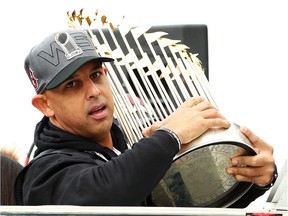 Alex Cora holds the World Series trophy during the Red Sox parade after winning the 2018 title.